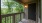 a wooden porch with a door and a window with trees outside
